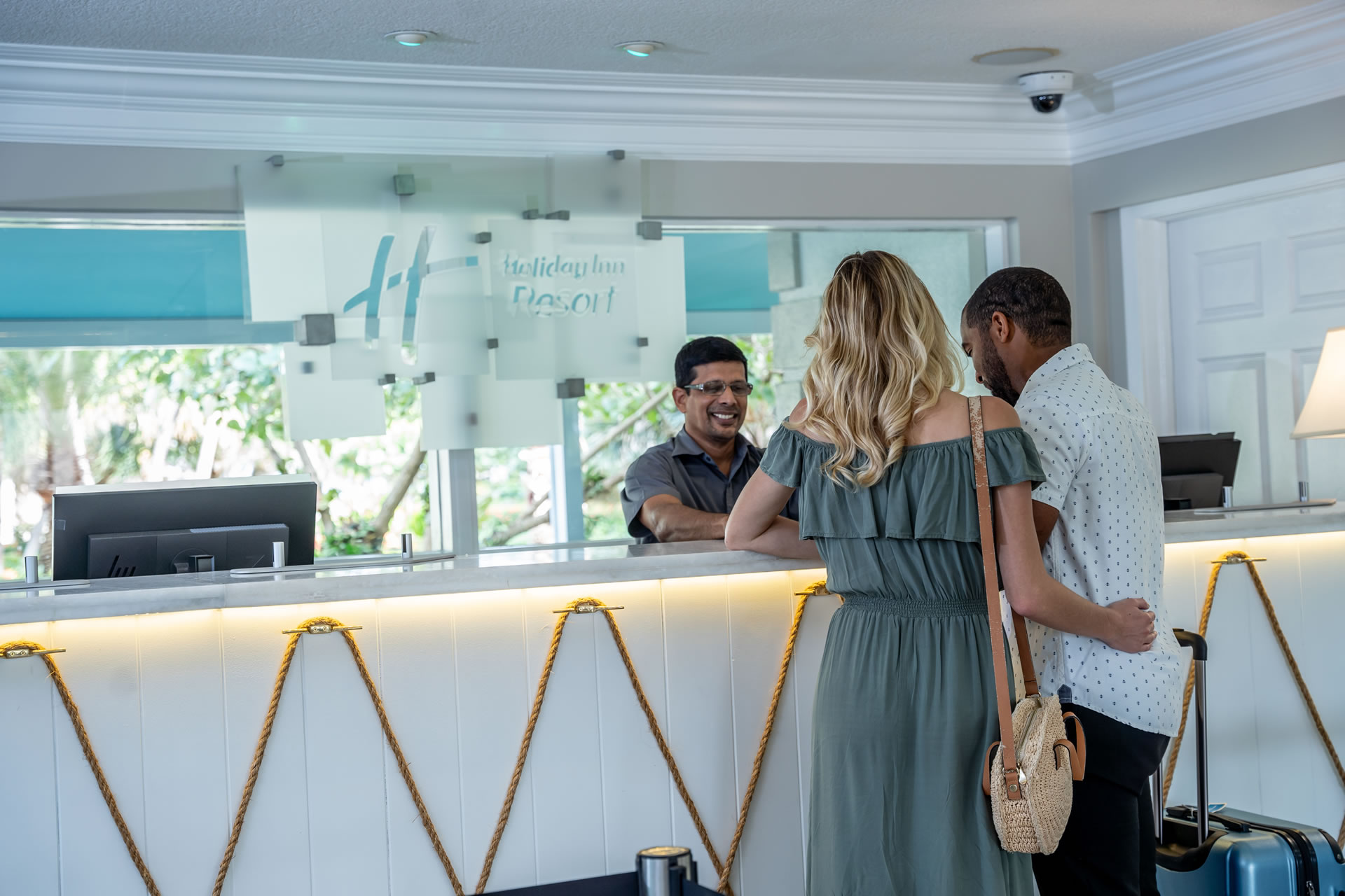 Couple checking in at the front desk of the Grand Caymanian Resort.