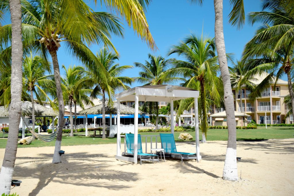 Lounge chairs under a cabana on the beach at Grand Caymanian Resort.