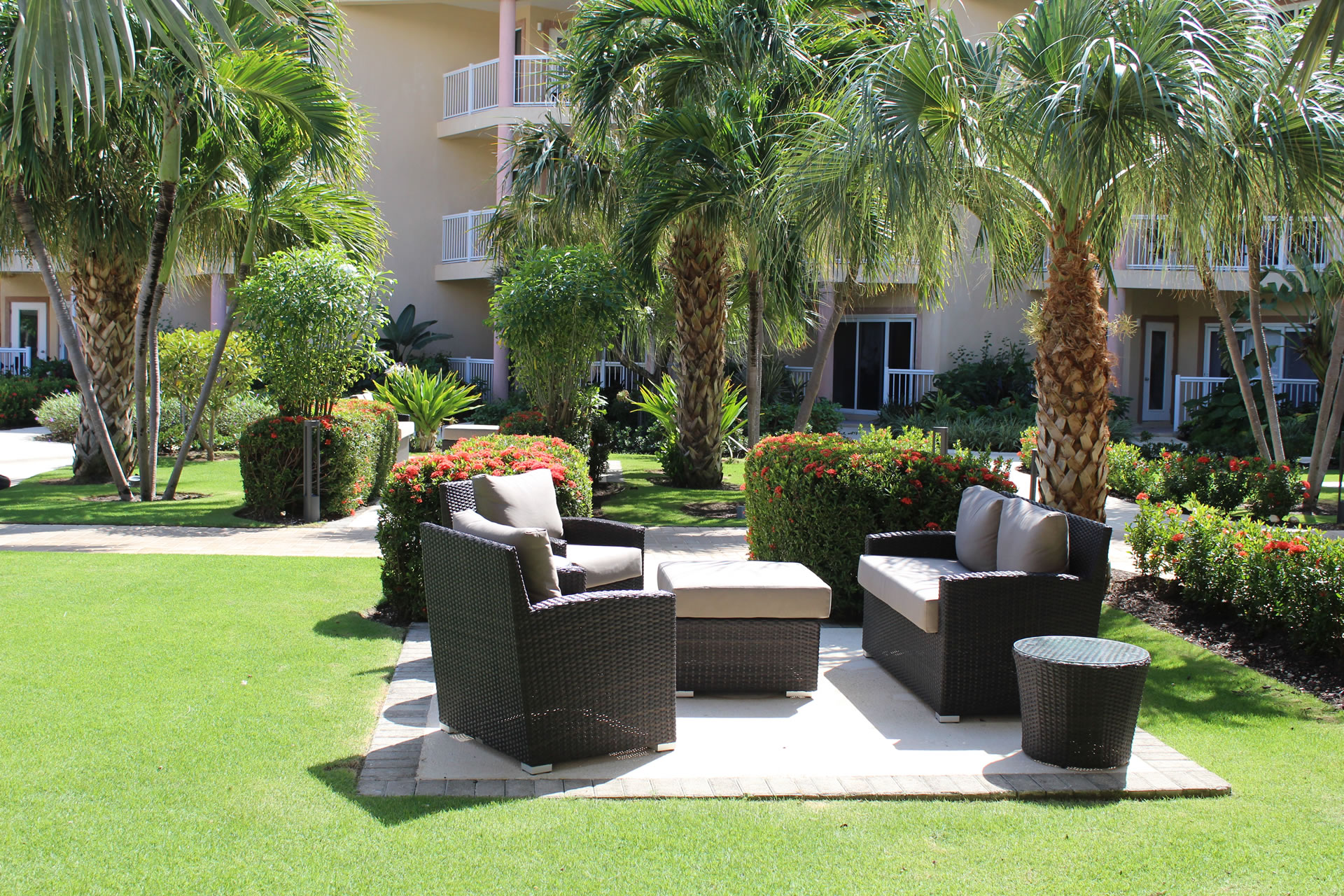 Outdoor patio furniture and seating area in the courtyard of the Grand Caymanian Resort.