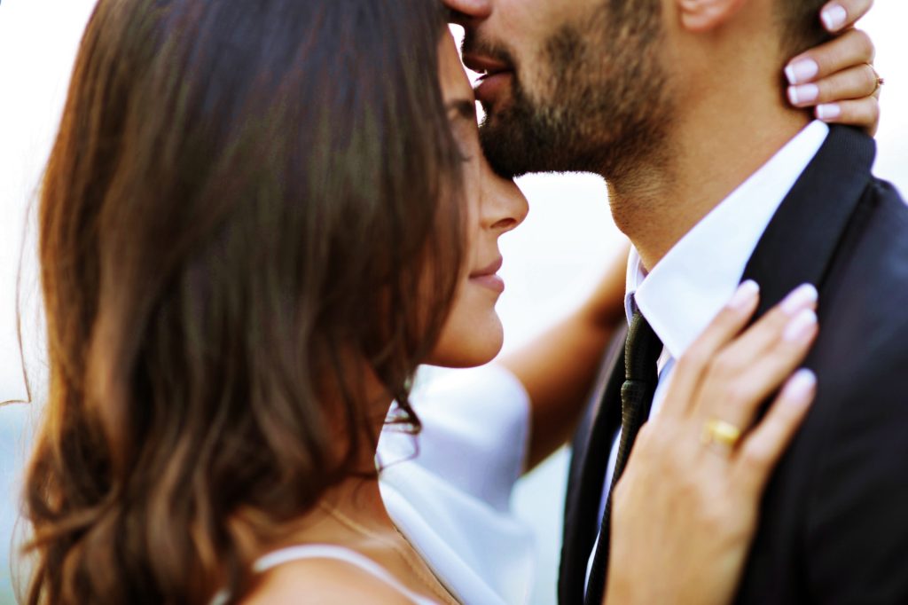 Close up of a bride and groom in a romantic embrace.