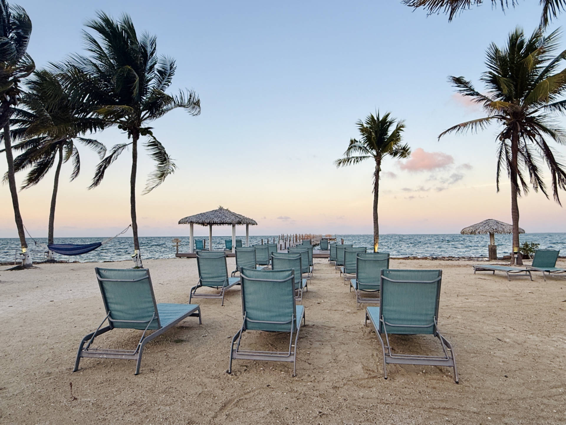 Beach lounge chairs lined up on the beach at Grand Caymanian Resort.