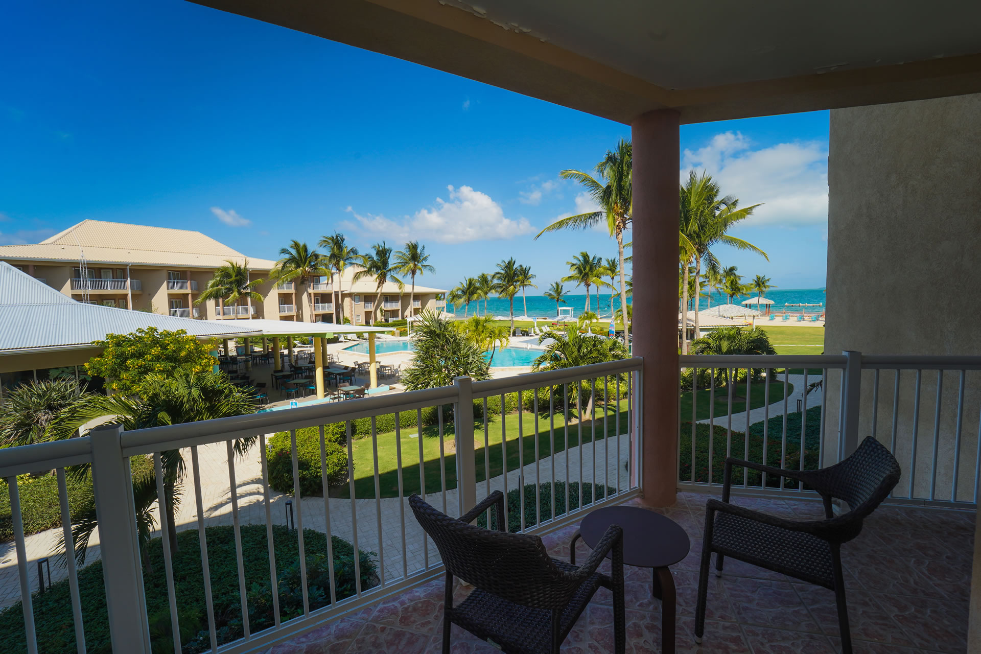 View of the resort pool and courtyard from the balcony of a guest suite at the Grand Caymanian Resort