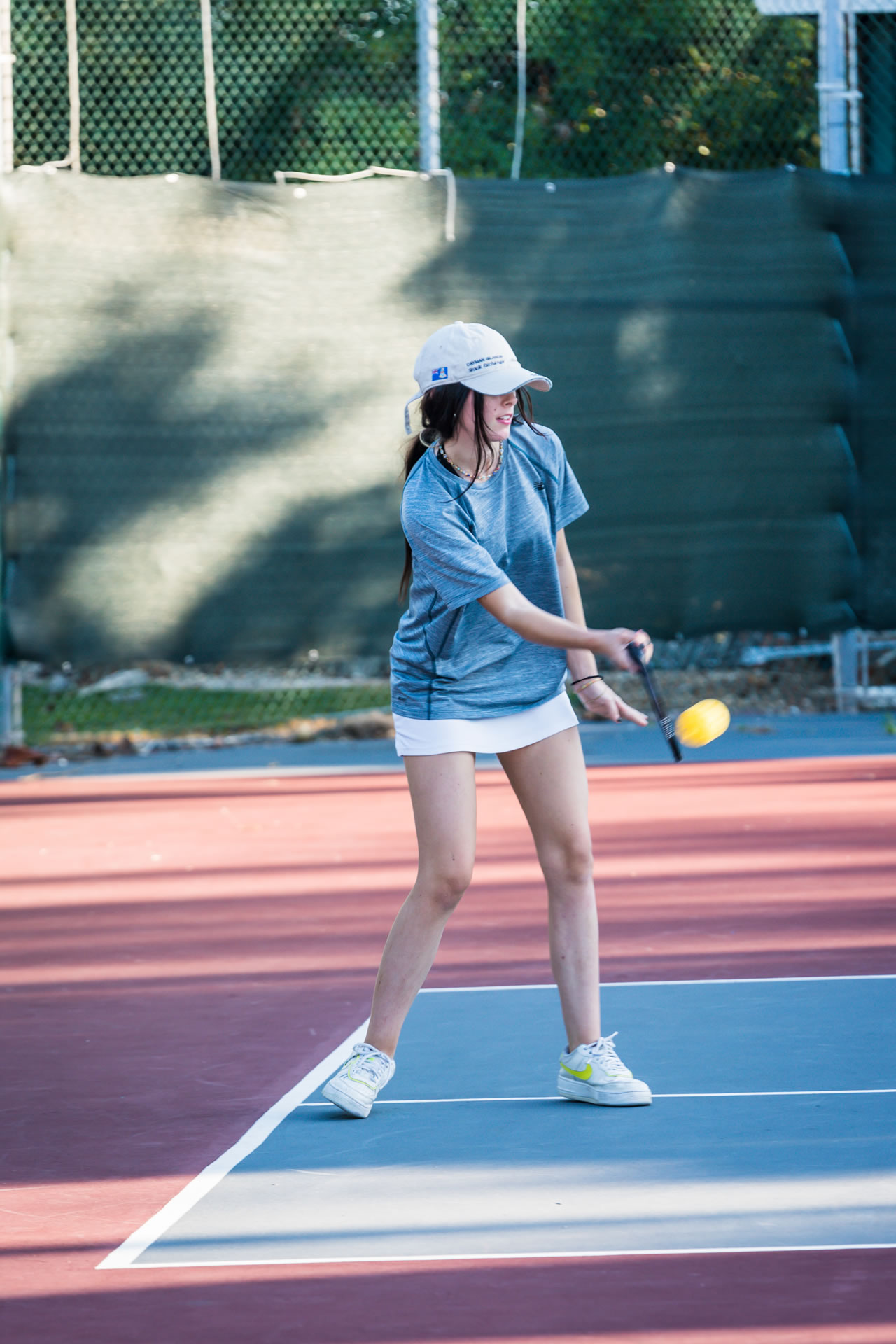 Young woman playing pickelball at the Grand Caymanian Resort.