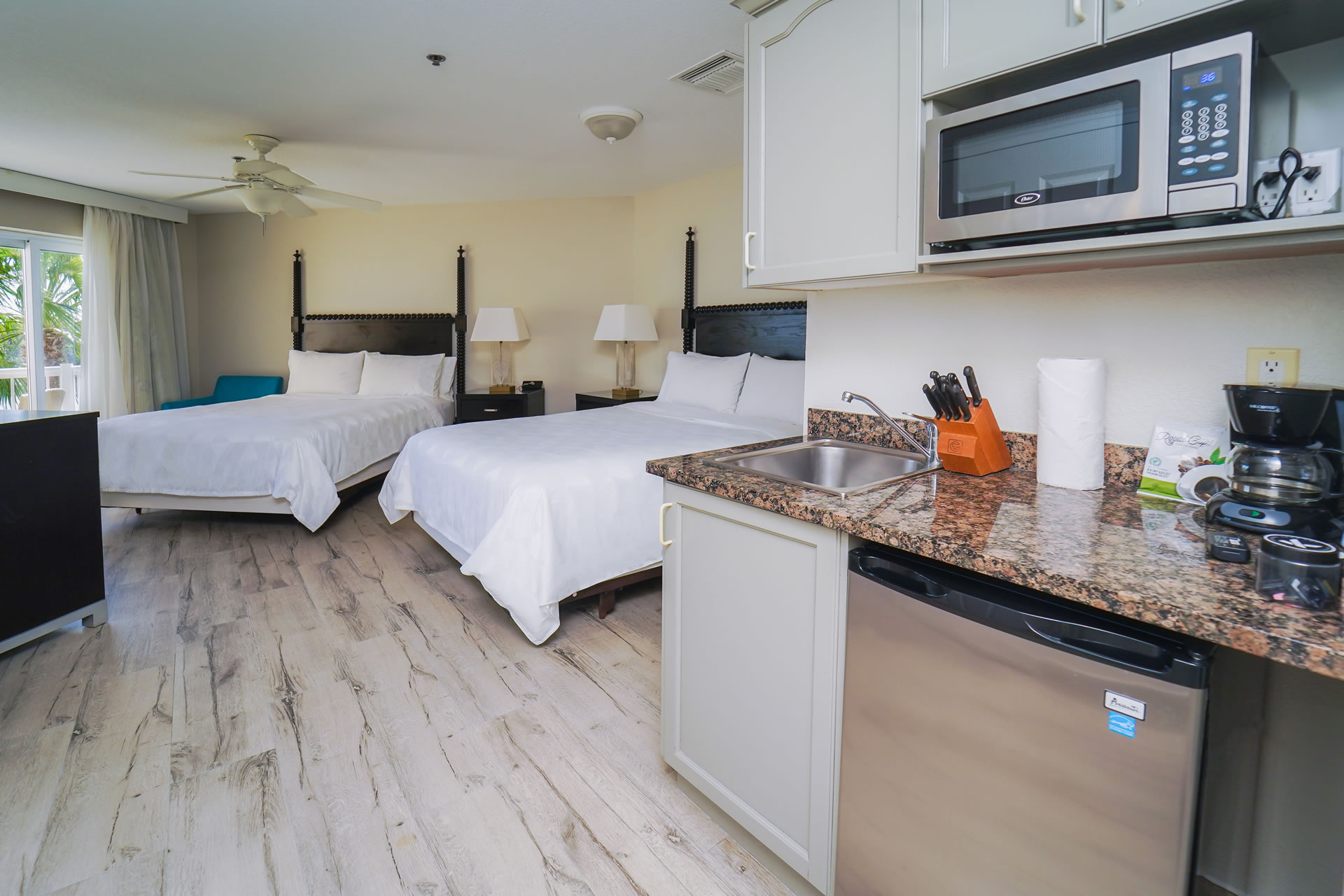 Two queen beds and kitchenette area in the Two Queen Bed Studio Suite at the Grand Caymanian Resort.