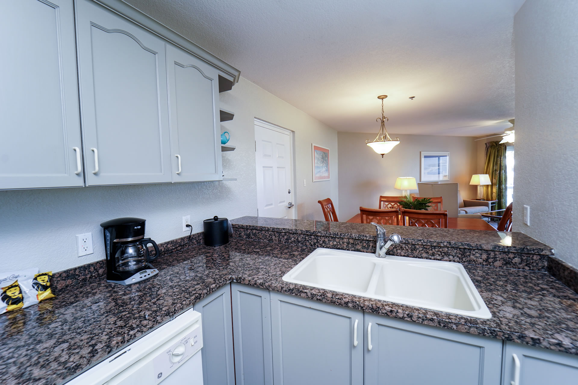 Kitchen area and dining room table in the One Bedroom King Suite at the Grand Caymanian Resort.