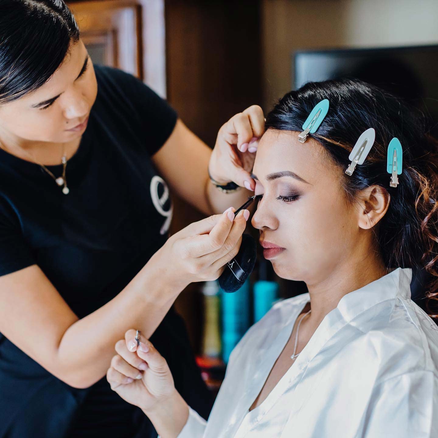 Makeup artist applying makeup to a customer.