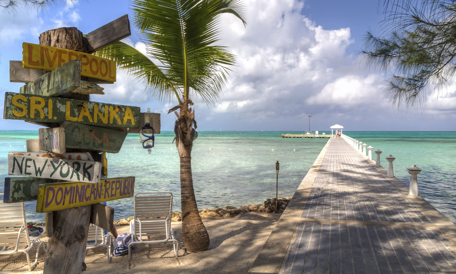 Signpost and pier at Rum Point Beach on Grand Cayman in the Cayman Islands..